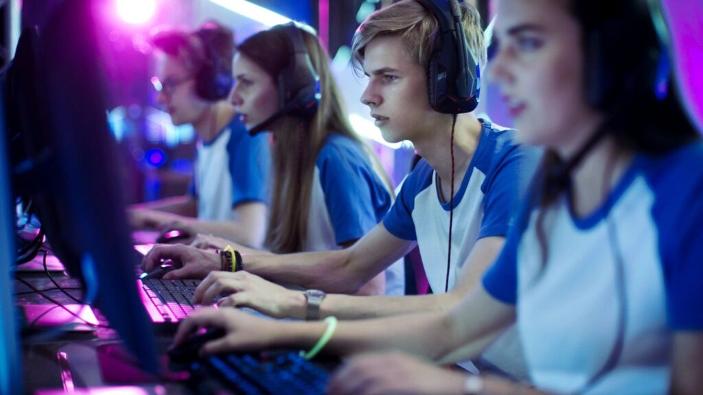 a picture of 4 people on the computer with headphones